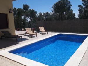 巴古尔Villa Hermosa的一个带两把椅子的游泳池和一个游泳池