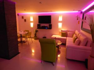 卡塔赫纳Apartment Lux Bocagrande的客厅配有紫色灯、沙发和桌子