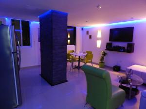 卡塔赫纳Apartment Lux Bocagrande的客厅配有桌椅和紫色灯