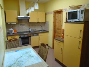 塞巴特阿尔贝克Ferienwohnung Emily的厨房配有黄色橱柜和一张带地图的桌子