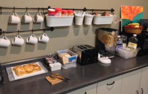 MondoviSunRise Inn Hotel的厨房柜台,上面有咖啡杯和食物