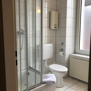 门兴格拉德巴赫精选酒店的一间带卫生间和玻璃淋浴间的浴室