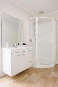 Te Whau Bay特瓦巴赫公寓的白色的浴室设有水槽和淋浴。