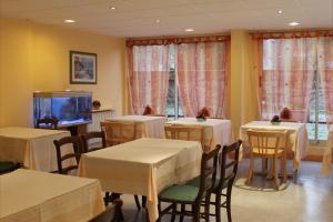 伊维特河畔吉夫乐维雷治酒店的一间带桌椅和电视的用餐室