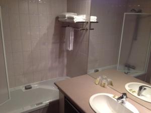 埃圭斯海姆Hotel Colmar Vignes Eguisheim的浴室配有水槽、淋浴和浴缸。
