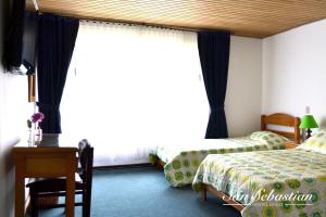 波哥大阿曼达住宿加早餐旅馆的一间卧室设有两张床和大窗户