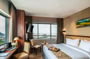 马卡萨Arthama Hotels Makassar的酒店客房配有一张床、一张书桌和一台电脑
