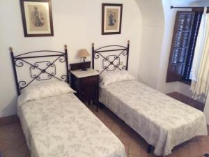 Castro del Río乡村别墅酒店的两张睡床彼此相邻,位于一个房间里
