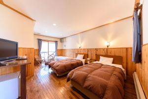 Shimo-tashiriGinga no Yado Kinoko2seigo的酒店客房设有两张床和一台平面电视。