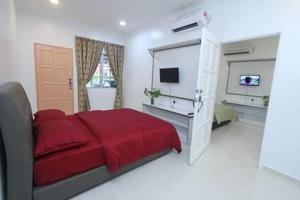 Pengkalan Cepa哥打巴鲁机场中转索菲宾馆的一间白色卧室,配有红色的床和电视