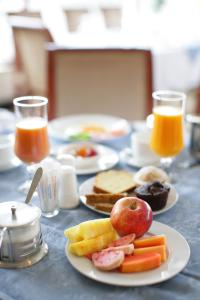 亚的斯亚贝巴Wassamar Hotel的餐桌,包括早餐食品和橙汁盘