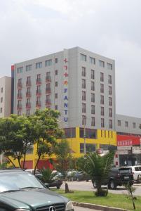 亚的斯亚贝巴Wassamar Hotel的一座大型建筑,前面有汽车停放