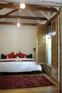 珍南海滩潘集潘集热带木屋别墅的一间卧室配有一张带红色枕头的大床