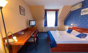 布达佩斯克拉希克酒店的配有一张床和一张书桌的酒店客房