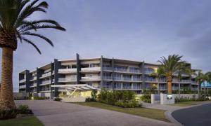 黄金海岸阿苏拉绿色度假酒店的一座棕榈树环绕的大建筑