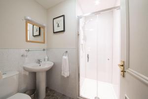 斯特灵Munro Guest House的带淋浴和盥洗盆的白色浴室