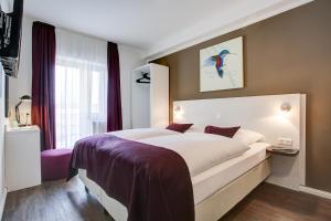 汉堡Hotel West的卧室配有一张大白色床和紫色床单