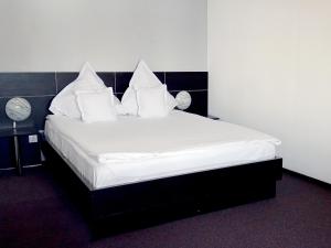 密古雷休治Prince Hotel的一间卧室配有带白色床单和枕头的床。