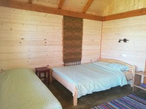 CesvaineRozītes的小木屋内一间卧室,配有两张床