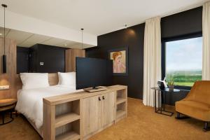 阿尔隆Van Der Valk Luxembourg Arlon的一间卧室设有一张大床和一台平面电视。