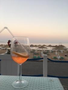 沙姆沙伊赫Holiday Rooms Domina Coral Bay的一张桌子上的一杯葡萄酒,享有海滩美景