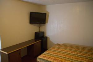 Tazewell塔兹韦尔汽车旅馆的一间卧室配有一张床和一台平面电视