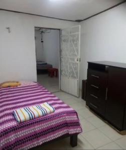 梅里达Casa Colonial Centro的一间卧室配有一张床、梳妆台和衣柜。