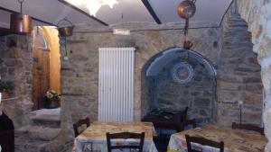 Roccasicura博尔格拉伏尔加住宿加早餐旅馆的一间设有两张桌子和石墙的用餐室