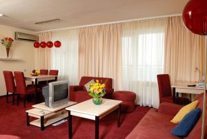 卡缅涅茨-波多利斯基波多利斯基卡米安奈斯七天酒店的一间带电视和红色椅子的客厅
