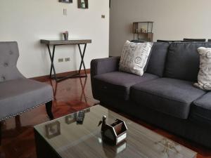 拉巴斯Miraflores Apart的客厅配有沙发和桌子