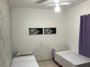 隆德里纳Pousada Hostel Universitário的墙上有两张照片的房间的两张床