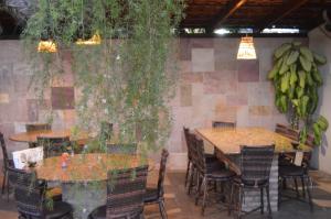 皮帕卡瓦罗马里尼奥旅馆的一间餐厅,餐厅内有桌椅和香蕉挂在墙上