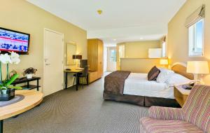 上哈特华莱士威尔汽车旅馆的酒店客房配有一张床、一张书桌和一张沙发。