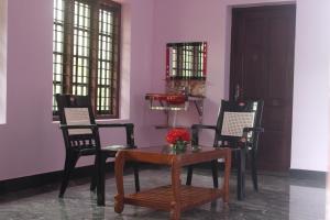特里凡得琅Puthenchirayil Homestay的一间配备有桌椅和紫色墙壁的用餐室