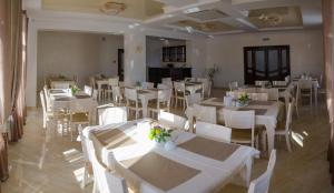 斯基希德尼萨Fortuna的用餐室配有白色的桌子和白色的椅子