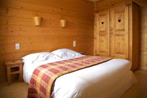拉穆拉Les Arobiers的木制客房内的一间卧室,配有一张床