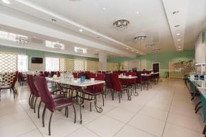 喀山桑纳特里尼克哈马酒店的用餐室设有桌椅和绿色的墙壁