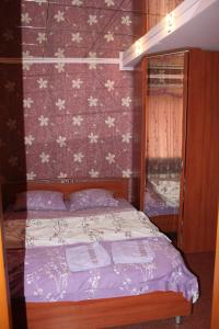 Leninsk-KuznetskiyШевцовой, 10的一间卧室配有一张带花卉壁纸的床