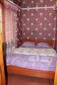 Leninsk-KuznetskiyШевцовой, 10的一间卧室配有一张紫色墙壁和鲜花的床
