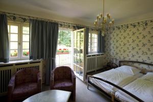 海尔布隆公园别墅酒店的一间卧室配有一张床、两把椅子和一个窗户