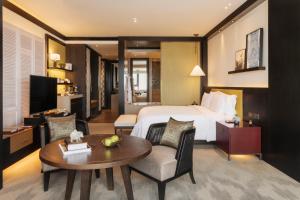 金边金边瑰丽酒店的酒店客房配有一张床铺和一张桌子。