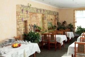 基希讷乌埃德姆酒店 的一间带桌子的用餐室和壁画墙