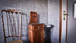 下麦克加诺Casa della Vittoria的一间带木制橱柜和椅子的浴室