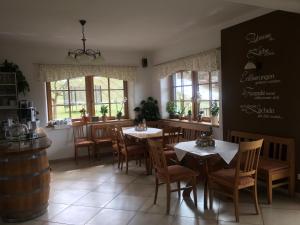 洛伊查赫Hopfenhof的用餐室设有桌椅和窗户。