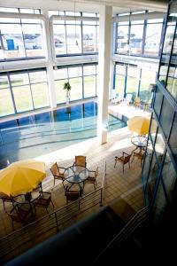 希茨海尔斯斯卡伽酒店的一座带游泳池、桌子和黄色遮阳伞的建筑