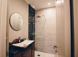 瓦莱塔莎莉港口套房公寓的浴室配有盥洗盆和带镜子的淋浴