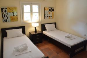 瓦西里科斯Villa Basta的带窗户的客房内设有两张单人床。