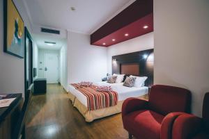 丰沙尔拉加马德拉穆图酒店的配有一张床和一把椅子的酒店客房