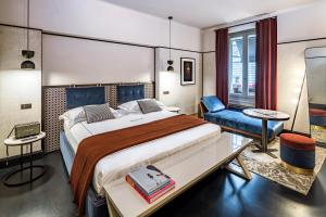 米兰洛坎达潘德努斯布雷拉住宿加早餐旅馆的一间卧室配有一张大床和一张蓝色椅子