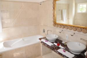 贝圣安那渔村酒店的浴室设有2个水槽、浴缸和镜子